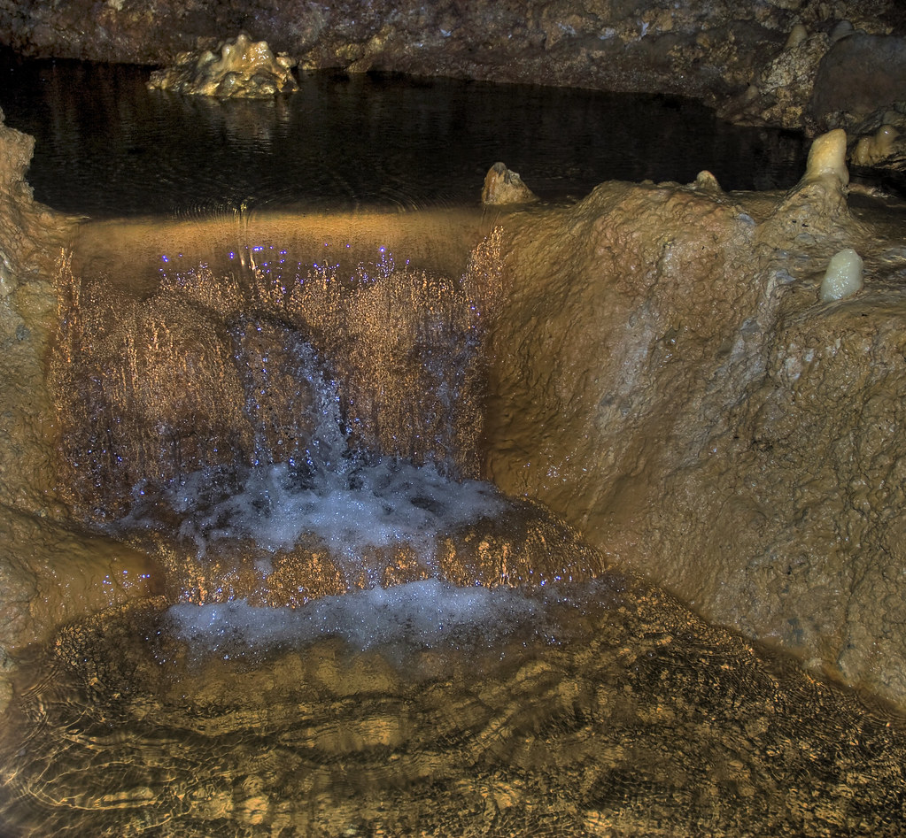 Unterirdischer Bachlauf fließt über geschichtete Kalksteinstufen in Harrison's Cave