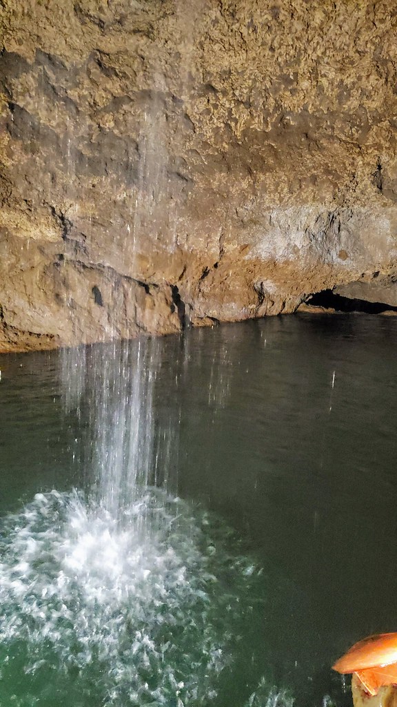 Unterirdischer Wasserfall ergießt sich in ein tiefes smaragdgrünes Karstbecken